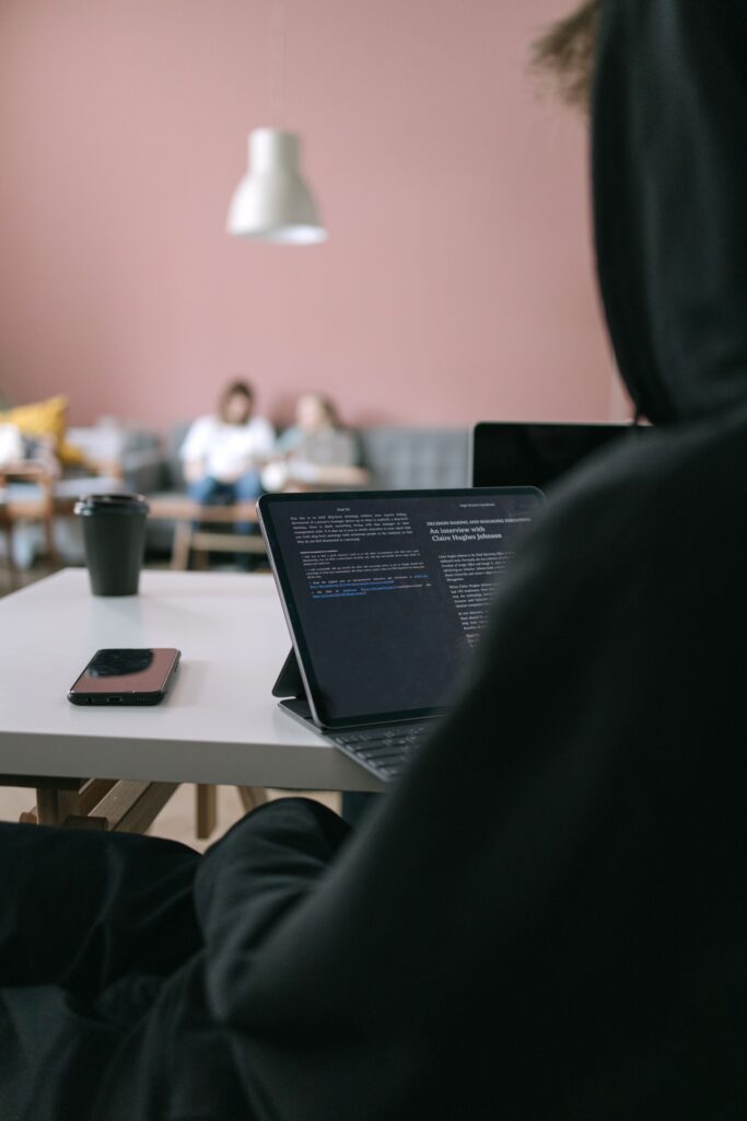 Young professional focused on laptop screen in modern workspace with casual ambiance.